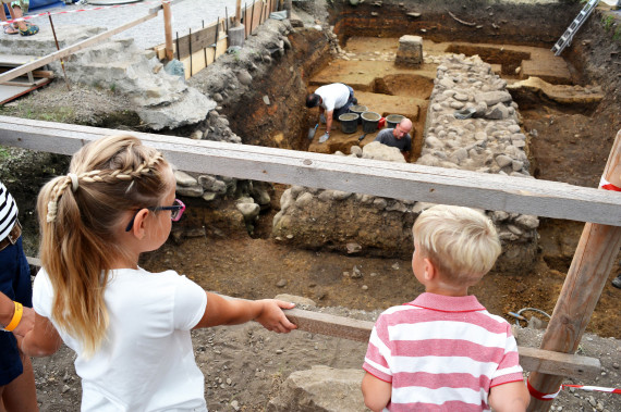 Zwei Kinder schauen bei Ausgrabungen zu